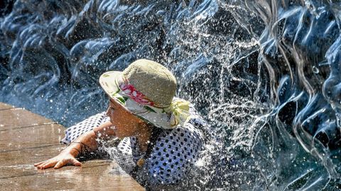 Una mujer se refresca en una fuente de Mosc