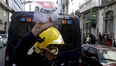 El bombero, con el cartel de Stop Desahucios en la mano.