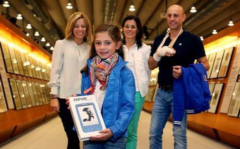 Candela Bedoya, acompañada por sus padres, recibió su «e-book» de manos de María García de Dios (izquierda).