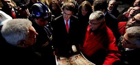 El presidente de la Xunta observa una reproducción del retablo barroco, flanqueado por el alcalde, el cura y el jefe de Protección Civil.