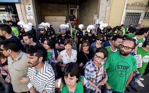 Colectivos antidesahucios formando una cadena humana frente a una casa para evitar el desalojo.