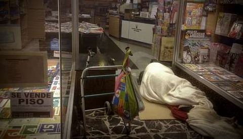 Un hombre durmiendo en el exterior de una librería en la ronda de Outeiro.