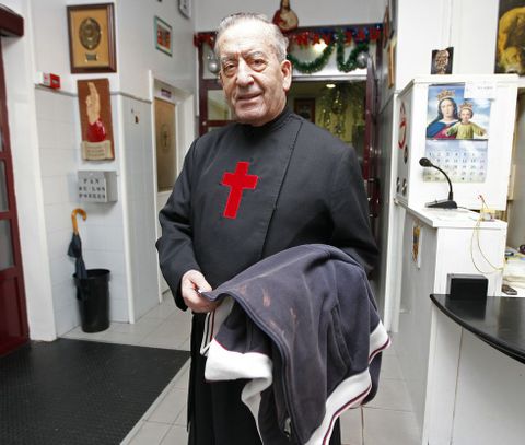 El hermano Donaire muestra la chaqueta de un indigente en el albergue de Teis, en Vigo.