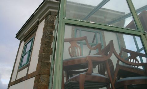 Sillas apiladas en la entrada del Semáforo que da a la terraza, en frente del Faro Fisterra.
