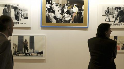 Dos hombres observan varias de las obras de la galería colombiana Doble Cero-Cero.