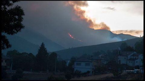 El humo del incendio visto desde Folgoso -la capital del municipio- en una imagen tomada con teleobjetivo a última hora de la tarde del sábado