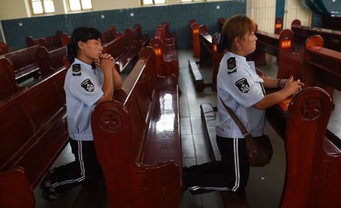 Dos integrantes de un coro rezan en su parroquia de Anyang.