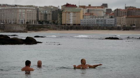 A pesar del temporal, gente bañándose en la playa de Riazor.