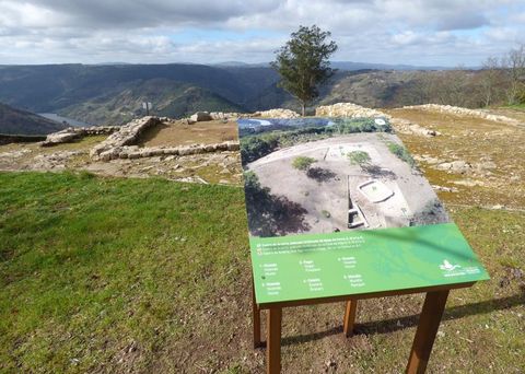 Un dos novos paneis situados xunto aos restos de estruturas construtivas desenterradas no castro
