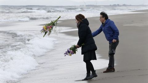 Mark Kanekita y Sadakuni Ito lanzan flores al mar en memoria de las víctimas.