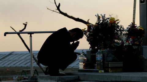 Un hombre reza ante un altar.