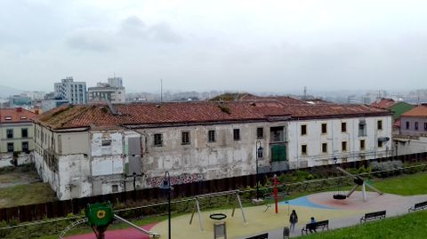 El edificio de Tabacalera, visto desde el cerro de Santa Catalina, con Gijón al fondo