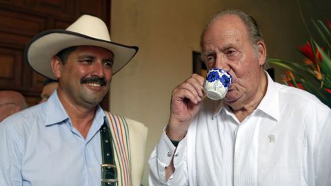 El rey emérito de España, Juan Carlos I, disfruta de un café junto a Juan Valdez, imagen internacional del café de Colombia.