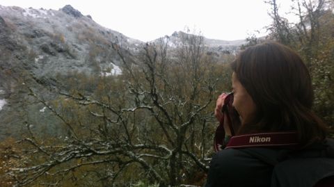 Una montañera saca una fotografía del bosque de Muniellos cubierto con la primera capa de nieve en la zona alta.Una montañera saca una fotografía del bosque de Muniellos cubierto con la primera capa de nieve en la zona alta
