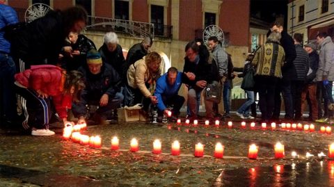 Varias personas encienden velas por las vctimas del VIH en la plaza Mayor de Gijn