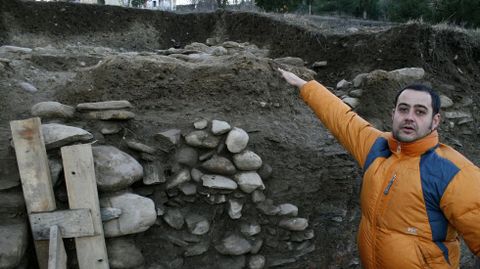 O arqueólogo Iván Álvarez Merayo mostra unha das estruturas aterrazadas da ladeira do monte de San Vicente sobre as que se levantaron as vivendas do castro