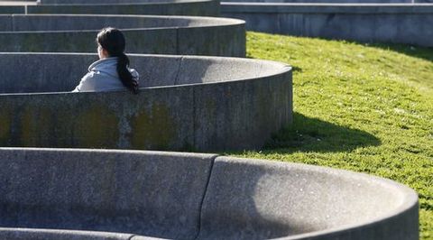 Una mujer sentada al sol en un parque de Oviedo