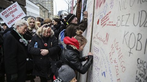 Varias mujeres escriben mensajes en el muro de la furia  ante la sede del Partido de Ley y Justicia en Varsovia, Polonia. 