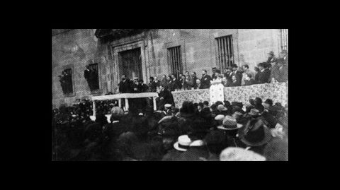 Un mitin ante la fachada del colegio en una fotografía de 1918