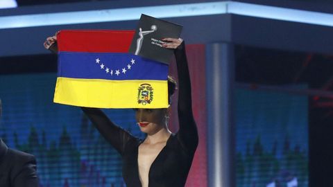 La actriz, directora y escritora venezolana Pakriti Maduro mostrando una bandera de su país al revés a modo de protesta
