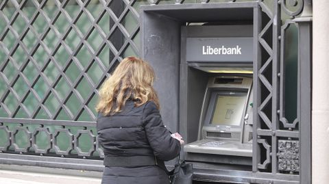 Una mujer saca dinero en un cajero de Liberbank