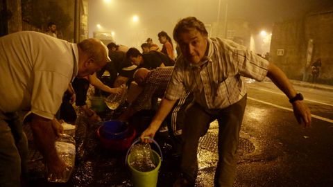 Vecinos de Vigo ayudan a apagar el incendio forestal que ha llegado hasta la calle Florida en el barrio de Navia