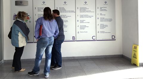 Un grupo de pacientes consulta la ubicación de los servicios en las consultas externas del HUCA.Un grupo de pacientes consulta la ubicación de los servicios en las consultas externas del HUCA