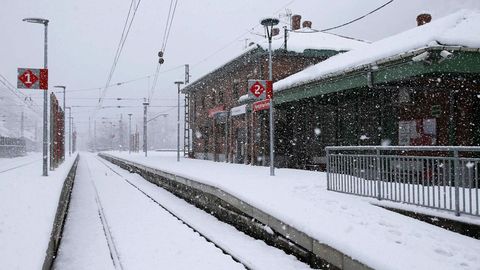 Vista de la estación de Puente de los Fierros, en Lena, que se encuentra cubierta por la nieve caída en las últimas horas. El temporal de nieve ha interrumpido esta mañana el tráfico ferroviario entre Asturias y León, por lo que Renfe ha puesto en marcha un plan alternativo de transporte de viajeros, lo que se suma a las importantes limitaciones en el tráfico por carretera entre el Principado y la Meseta.