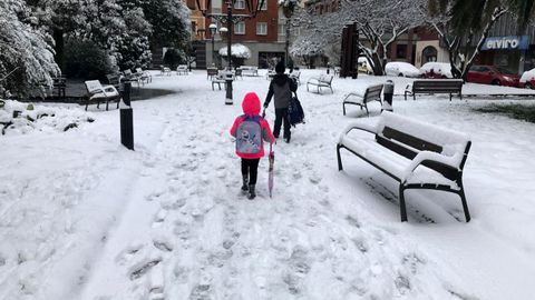 Escolares camino del colegio, sobre la nevada, en El Entrego