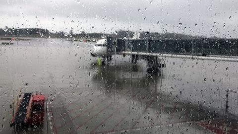 Un avión en un «finger» del Aeropuerto de Asturias, en medio de la lluvia