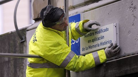 Un operario trabaja en la sustitución de la placa de la calle 19 de Julio, en el centro de Oviedo, en aplicación de la ley de Memoria Histórica por parte del Ayuntamiento de Oviedo