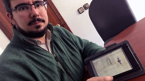 Álvaro Solona, medievalista de la Universidad de Oviedo, muestra un cartel vinculado al Camino del Salvador