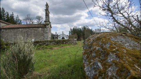 La iglesia de San Xulián y, en primer término, un peñasco con petroglifos