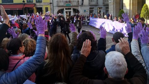 Manifestantes alzan las manos en la concentración feminista de la Plaza Mayor gijonesa