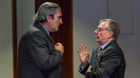 El consejero de Sanidad de Asturias, Francisco del Busto (d) y el diputado del PP. Carlos José Suárez, conversan en los pasillos de la Junta