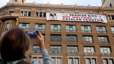 Un grupo de independentistas ha colgado una pancarta en contra del rey en la fachada de un edificio de la plaza de Catalua de Barcelona, donde se va a celebrar el acto central en recuerdo de las vctimas de los atentados del 17A. 