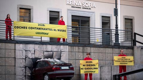Un coche «empotrado» en un museo para que las emisiones sean historia, una acción reivindicativa de Greenpeace, en la fachada del Reina Sofía de Madrid