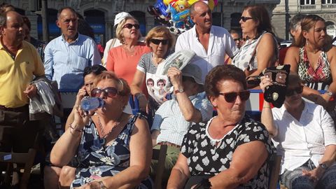 Asistentes al desfile del Día de América se protegen del sol y las altas temperaturas