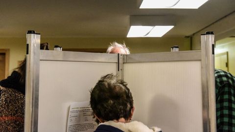 Dos personas votando en cabinas, en Vermont