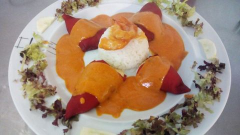 Entrante. Una ración abundante de pimientos del piquillo rellenos de bacalao y salsa de «cherrys»