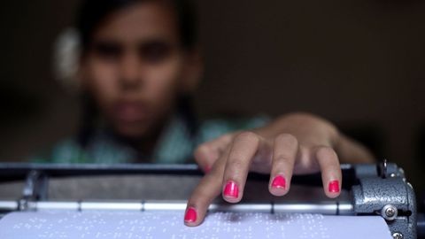 Una nia con discapacidad visual lee en braille