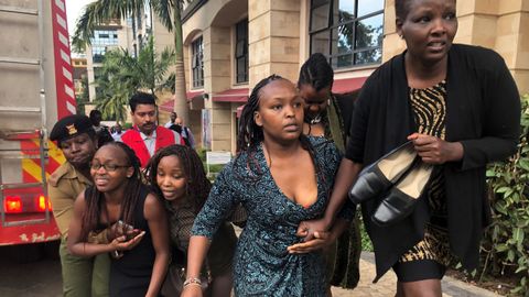 Un grupo de personas buscan refugio en la zona donde se produjo la explosión y los disparos, en un hotel de Nairobi, en Kenia
