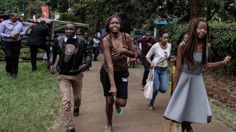 Un grupo de personas buscan refugio en la zona donde se produjo la explosión y los disparos, en un hotel de Nairobi, en Kenia