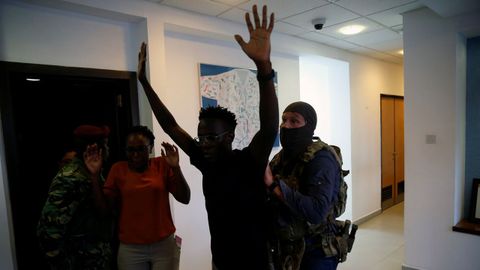 Un grupo de agentes cachean a un hombre en el interior del complejo