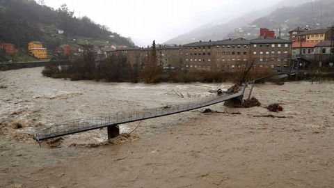Aspecto que presenta una pasarela peatonal sobre el ro Aller a causa del temporal de lluvias registrado en los ltimos das en Asturias