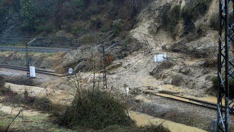 Aspecto que presenta la va de tren y la carretera comarcal a su paso por Laviana a causa del temporal de lluvias registrado en los ltimos das en Asturias