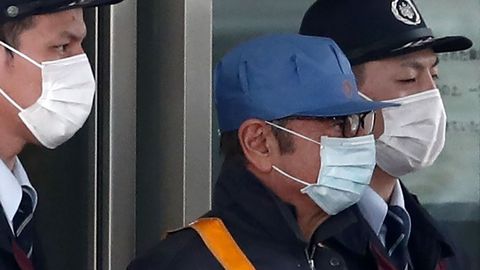 Carlos Ghosn (con gorra azul) a su salida de prisin