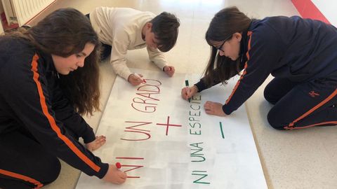 Carla, Aaron y Cintia preparan los carteles para la protesta. m. Leirós