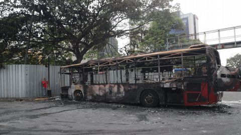 Restos de un autobs quemado durante los enfrentamientos del martes entre partidarios de Maduro y de Guaid