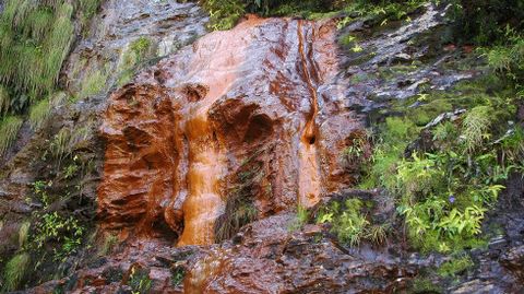 El agua ferruginosa colorea la pared de roca en la Fonte do Cervo